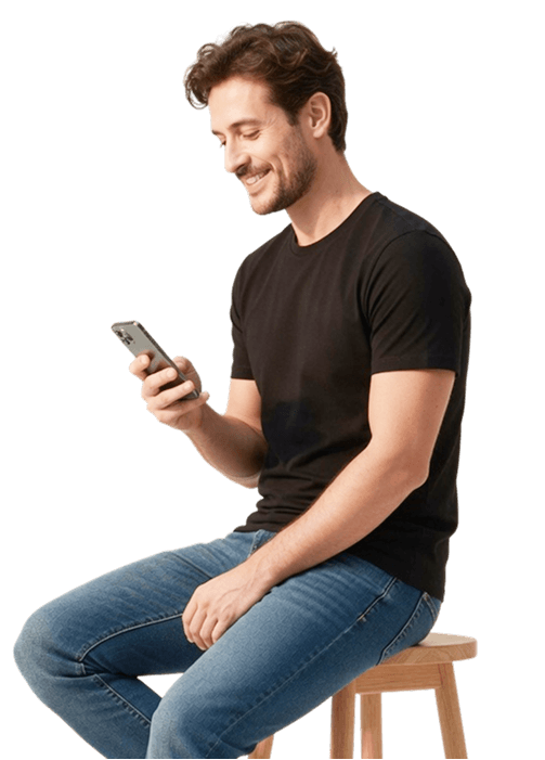 Homem sorrindo, de camiseta preta, olhando para o celular